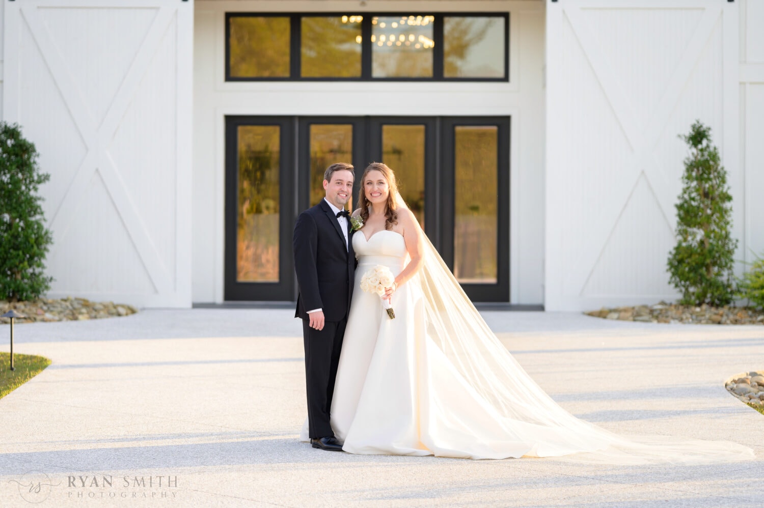 Portraits of bride and groom in front of the black doors - The Venue at White Oaks Farm