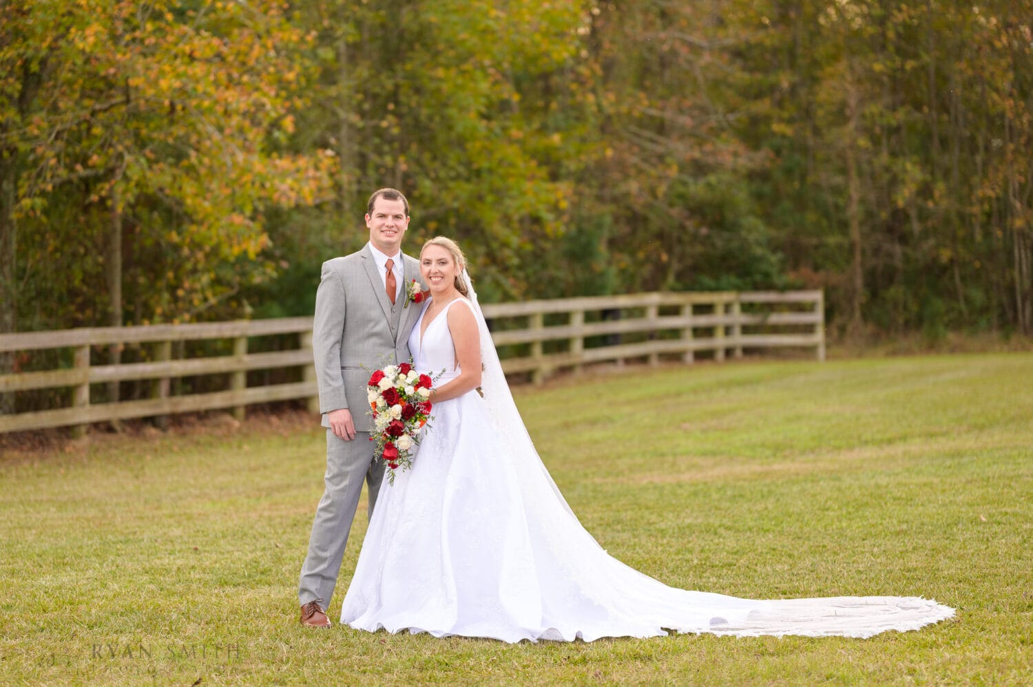 Bride and groom portraits by the fence - The Blessed Barn