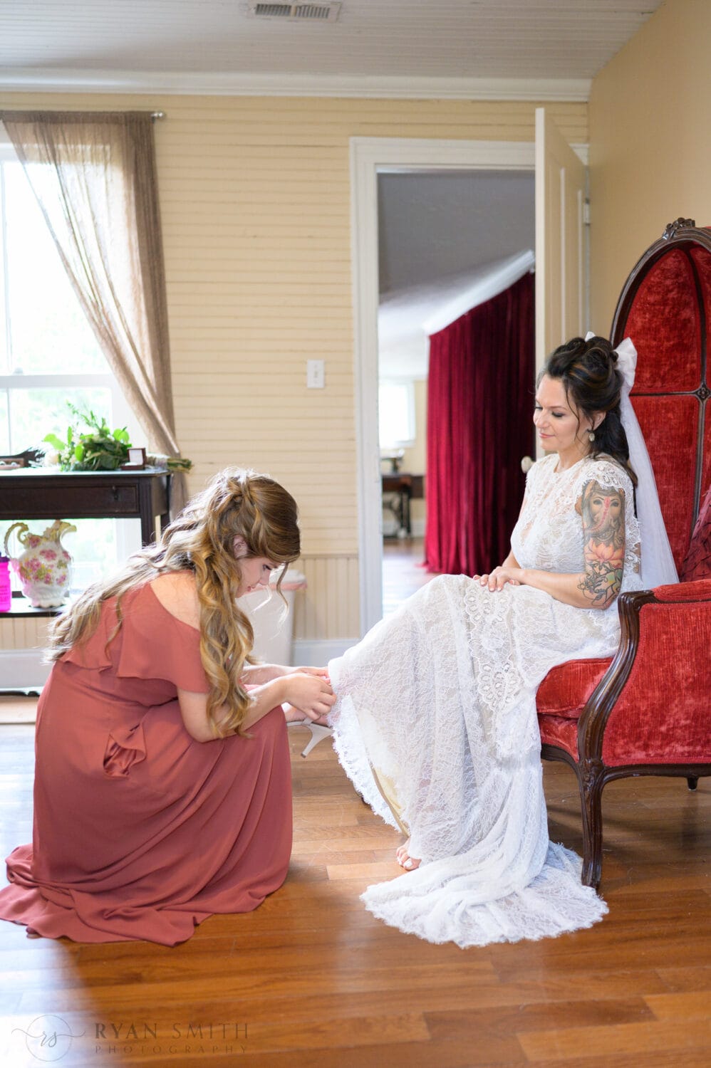 Bride's daughter putting on bride's shoes - The Cooper House