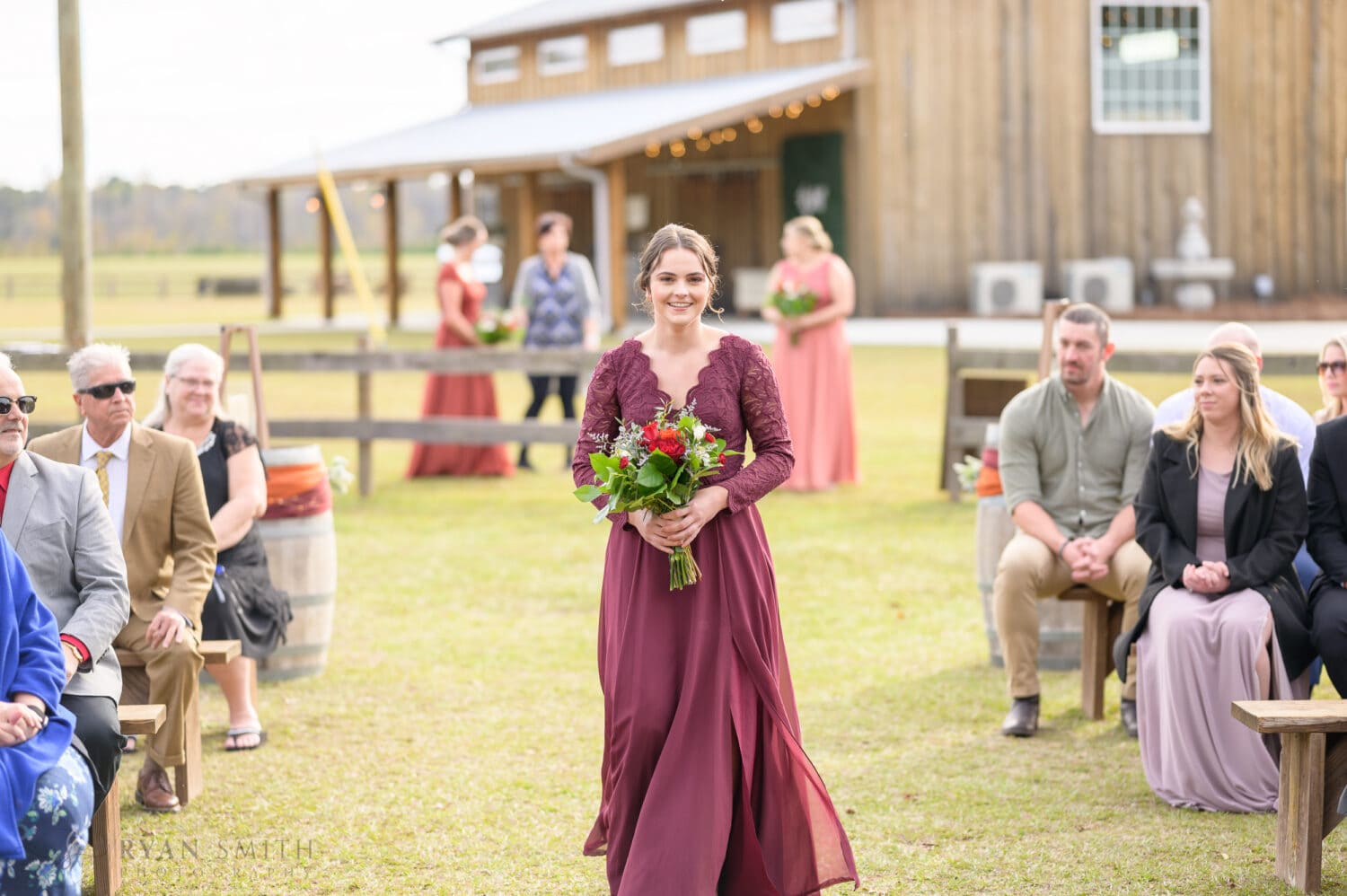 Bridesmaid walking to the ceremony - The Blessed Barn