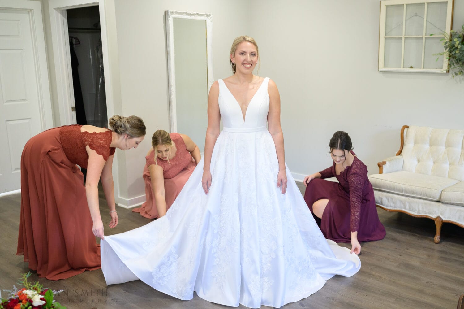 Bridesmaids fluffing out the dress - The Blessed Barn