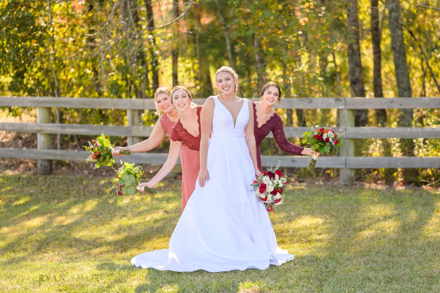 Bridesmaids peeking out from behind the bride - The Blessed Barn