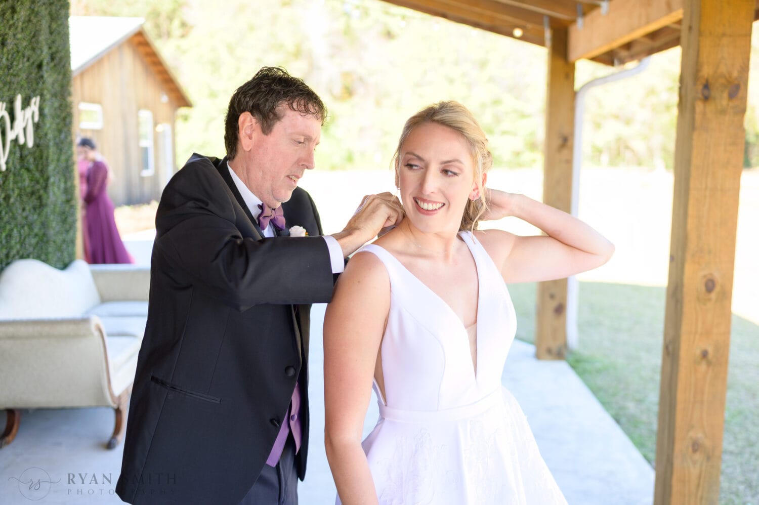 Dad helping bride with necklace  - The Blessed Barn