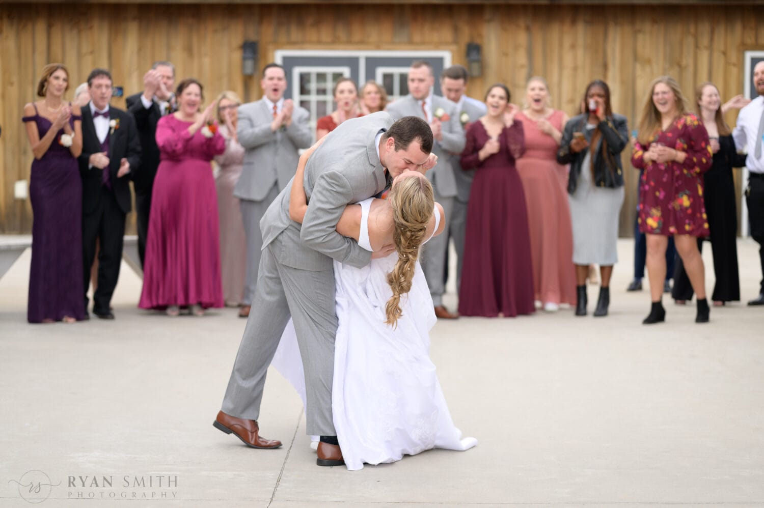 First dance with the bride and groom and family standing in the background - The Blessed Barn