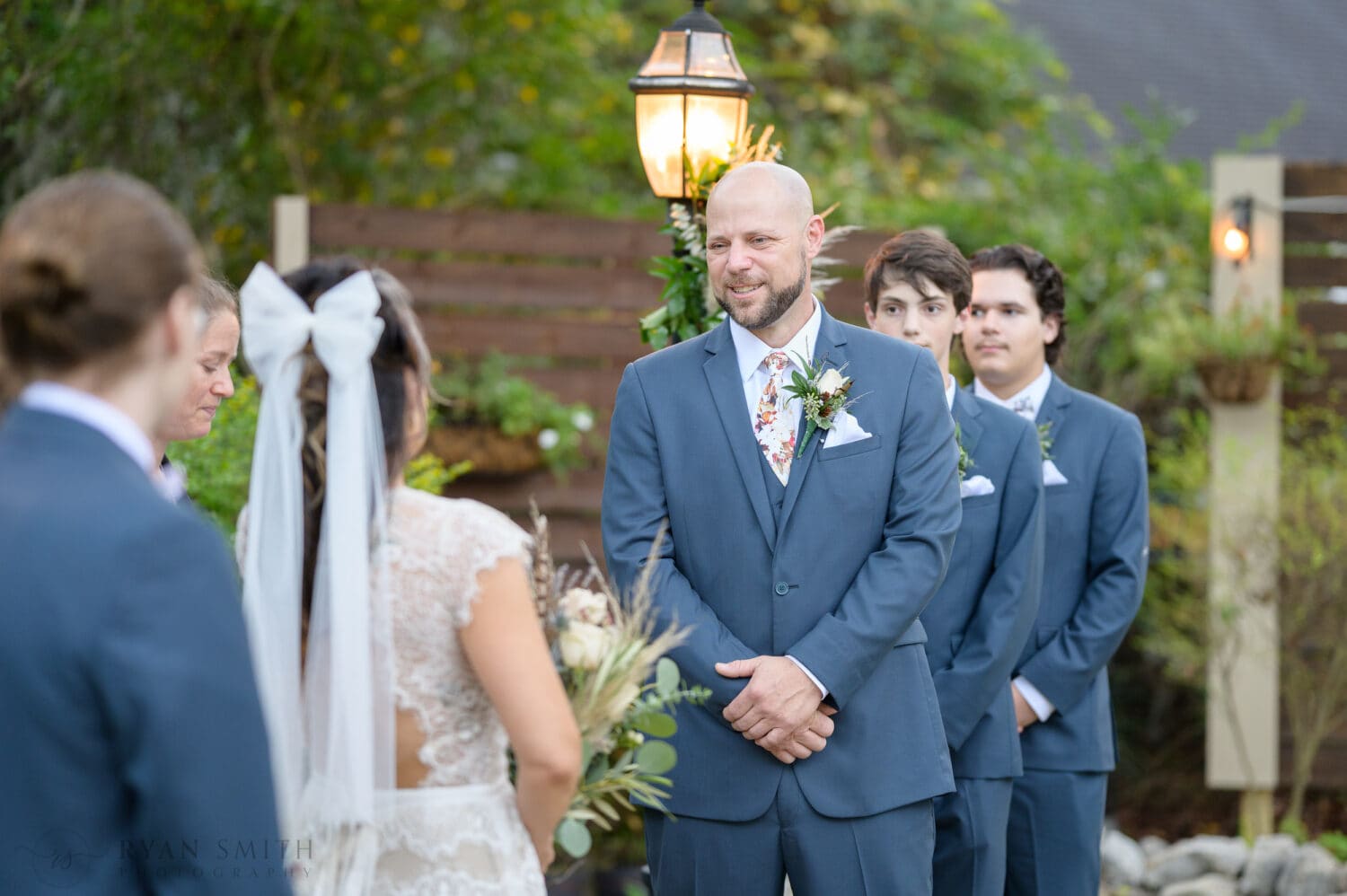 Groom smiling at bride during the ceremony - The Cooper House