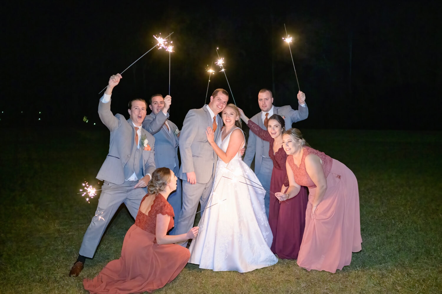 Holding sparklers around the bride and groom - The Blessed Barn