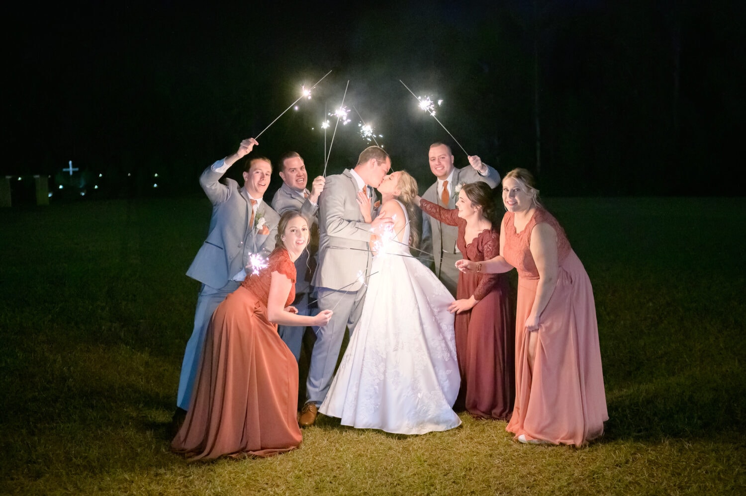 Holding sparklers around the bride and groom - The Blessed Barn
