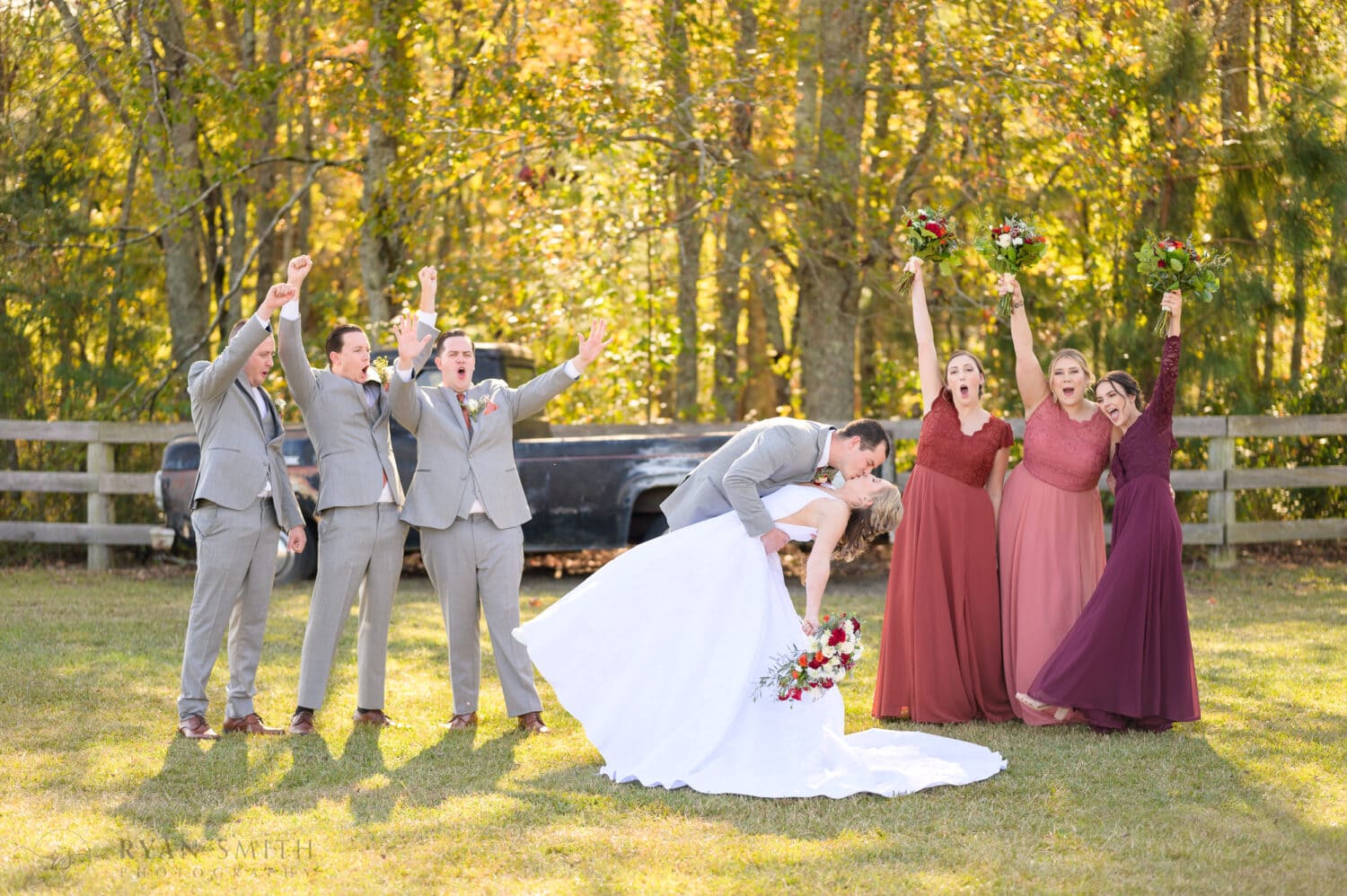 Wedding party cheering for bride and groom kiss - The Blessed Barn