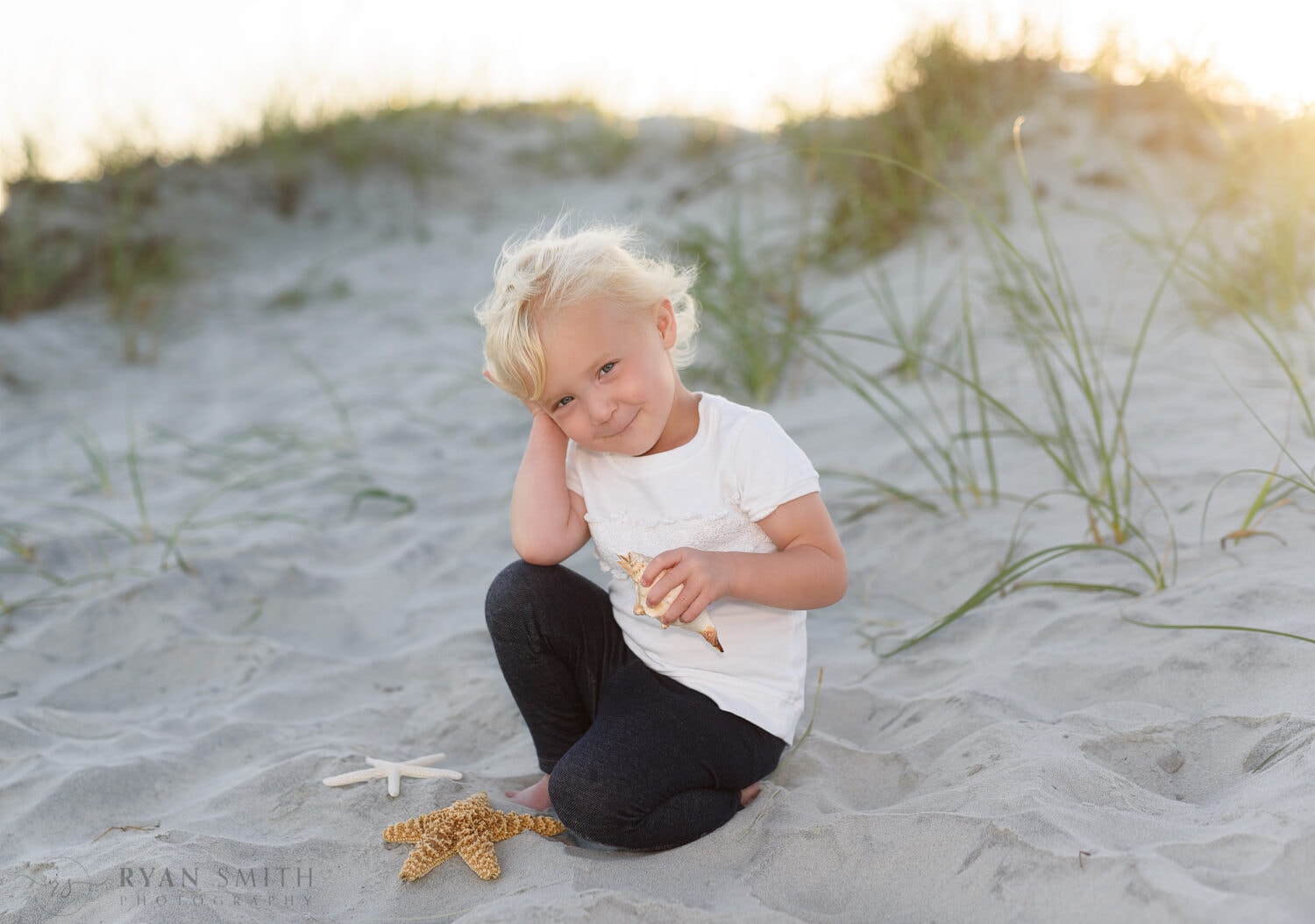 Baby girl having fun with shells by the dunes - Myrtle Beach State Park