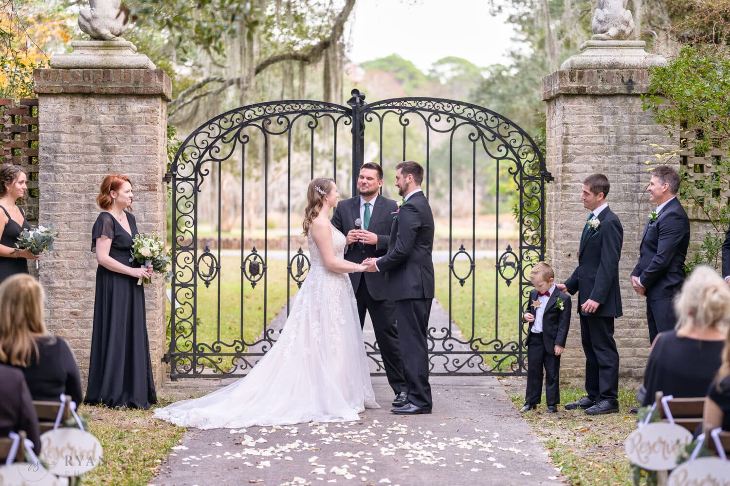 Bride and groom holding hands during the ceremony - Brookgreen Gardens