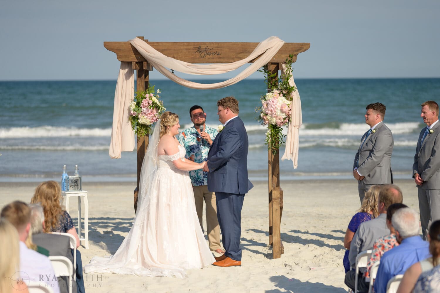 Bride and groom holding hands during the ceremony - Pawleys Island Beach House