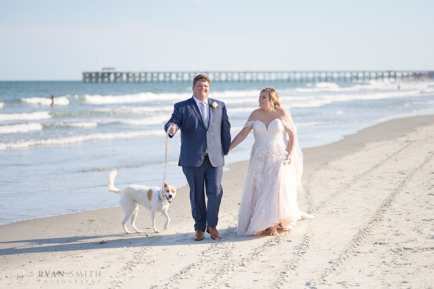 Bride and groom walking down the beach with their dog - Pawleys Island Beach House