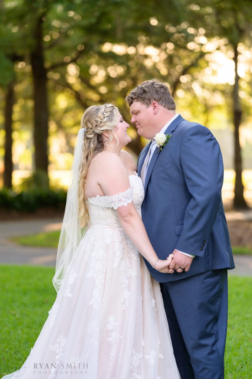 Portraits of bride and groom in front of the clubhouse in the sunset - Pawleys Plantation