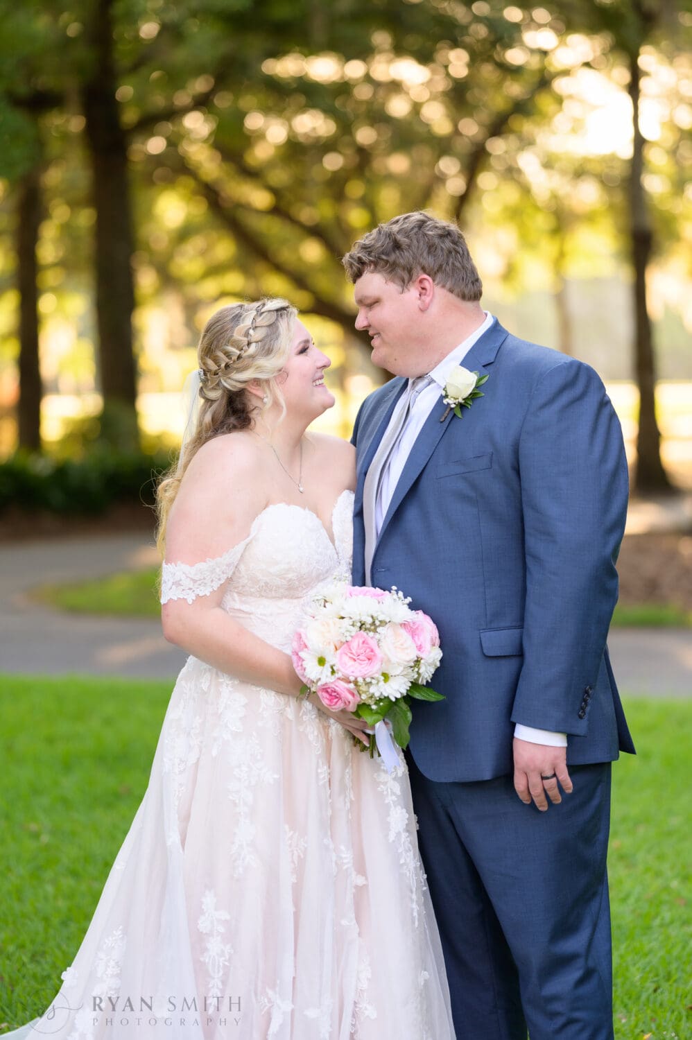 Portraits of bride and groom in front of the clubhouse in the sunset - Pawleys Plantation