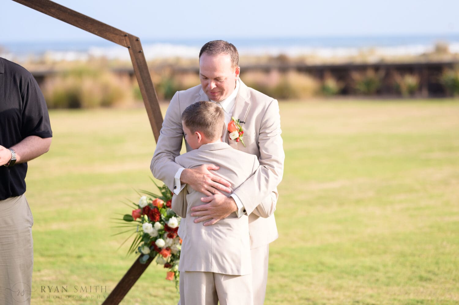 Dad hugging son during the ceremony - Dunes Golf & Beach Club