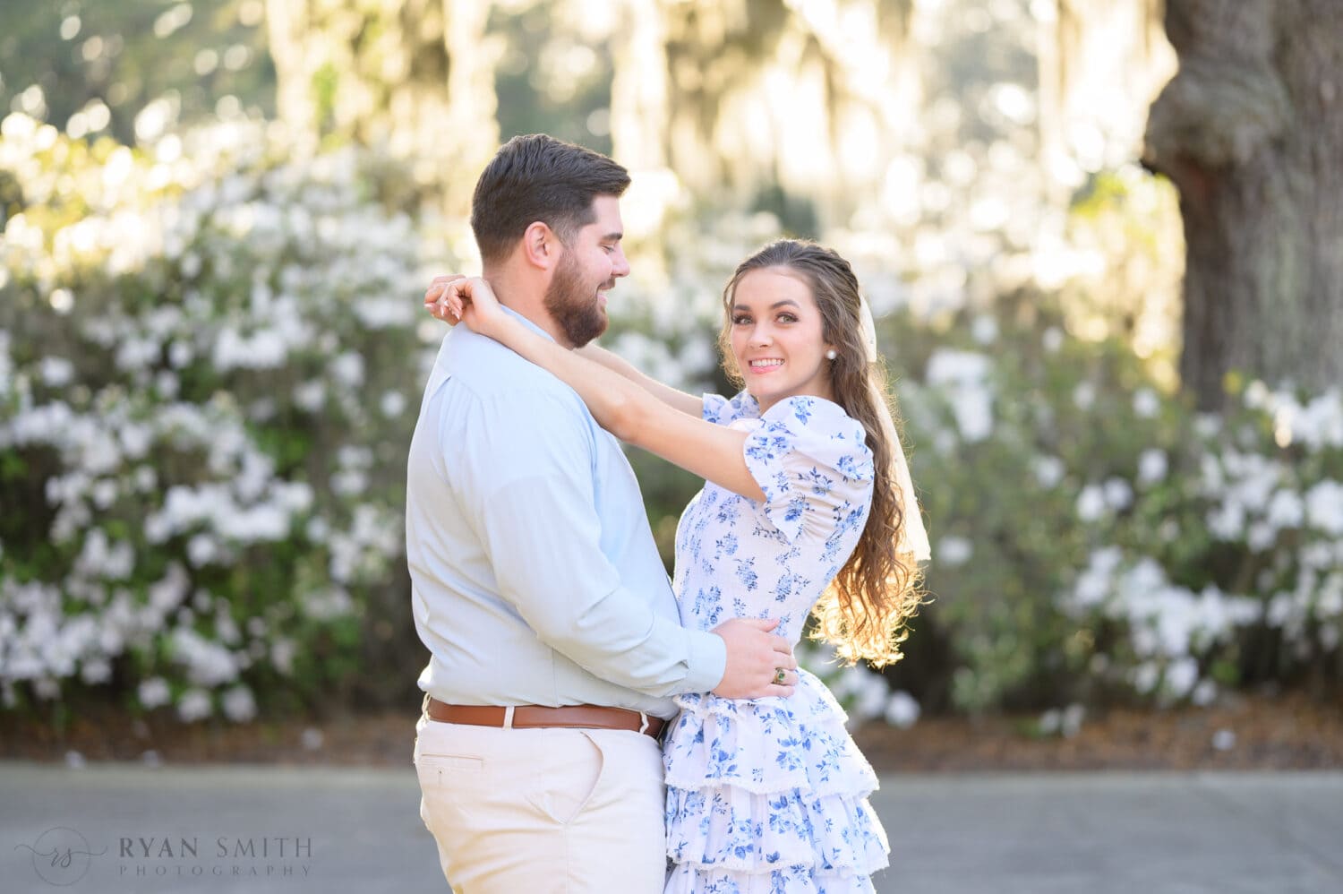 Engagement pictures in front of the white flowers - Caledonia Golf and Fish Club