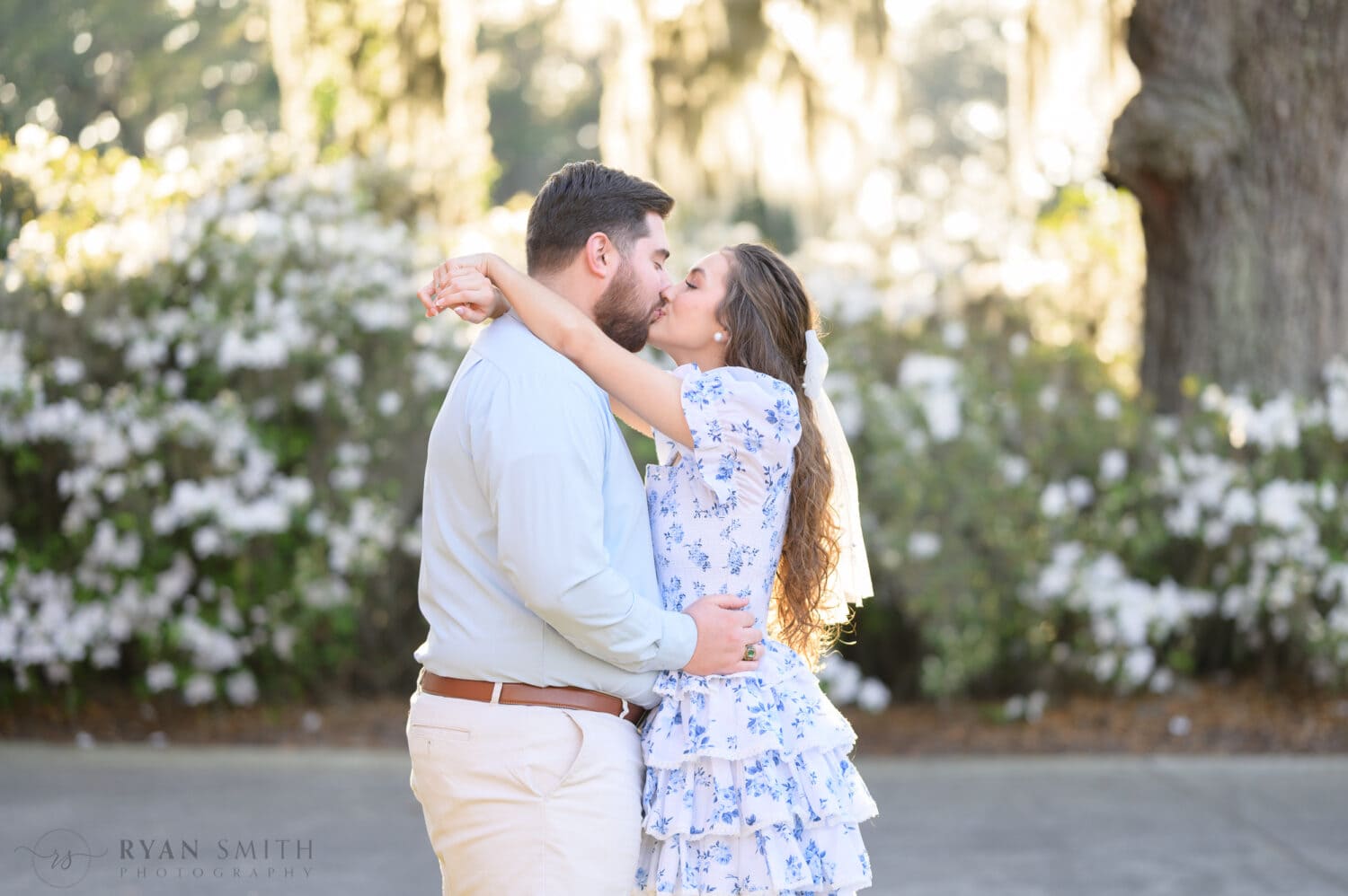 Engagement pictures in front of the white flowers - Caledonia Golf and Fish Club