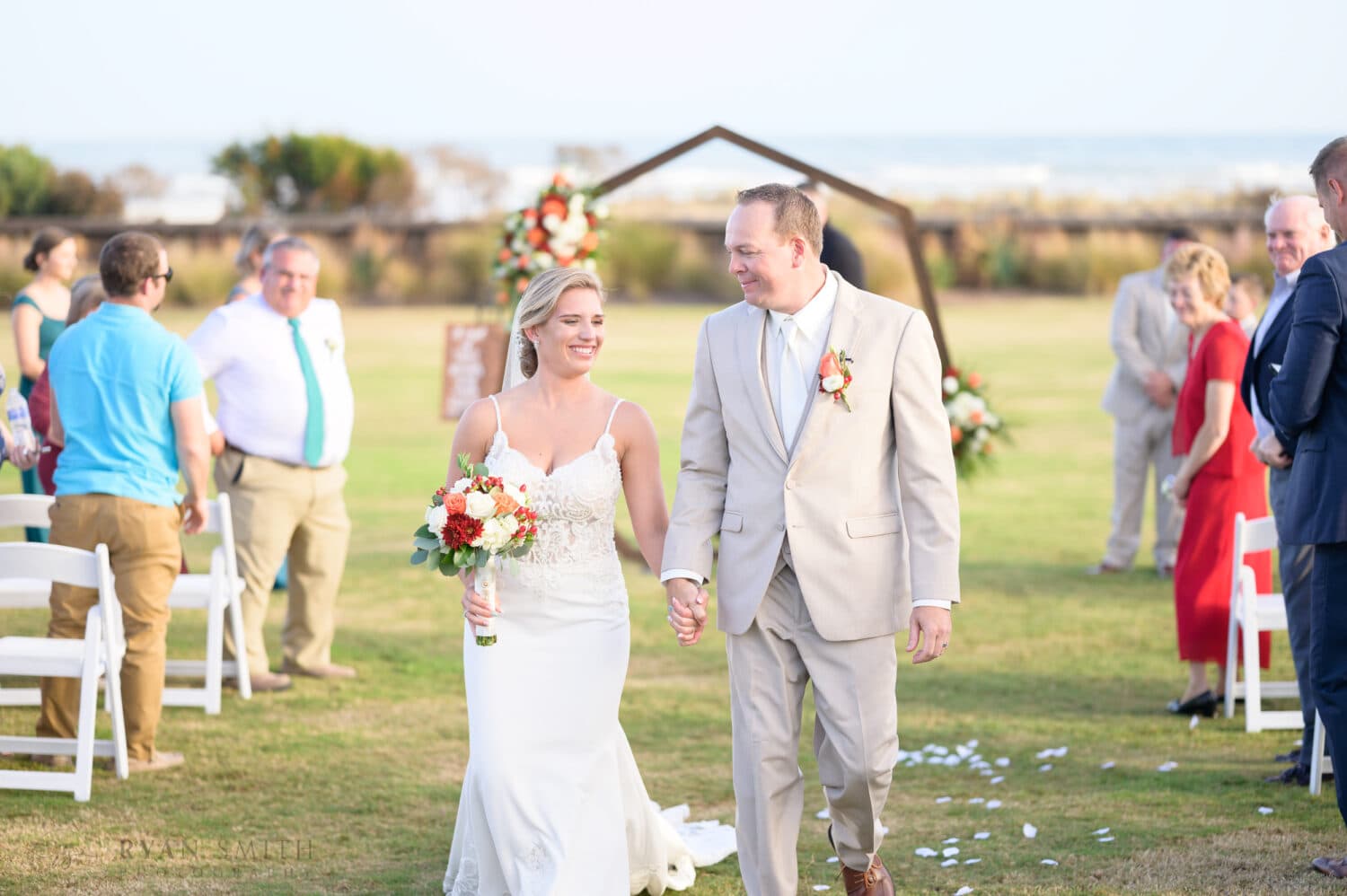 Happy bride and groom walking away from the ceremony - Dunes Golf & Beach Club