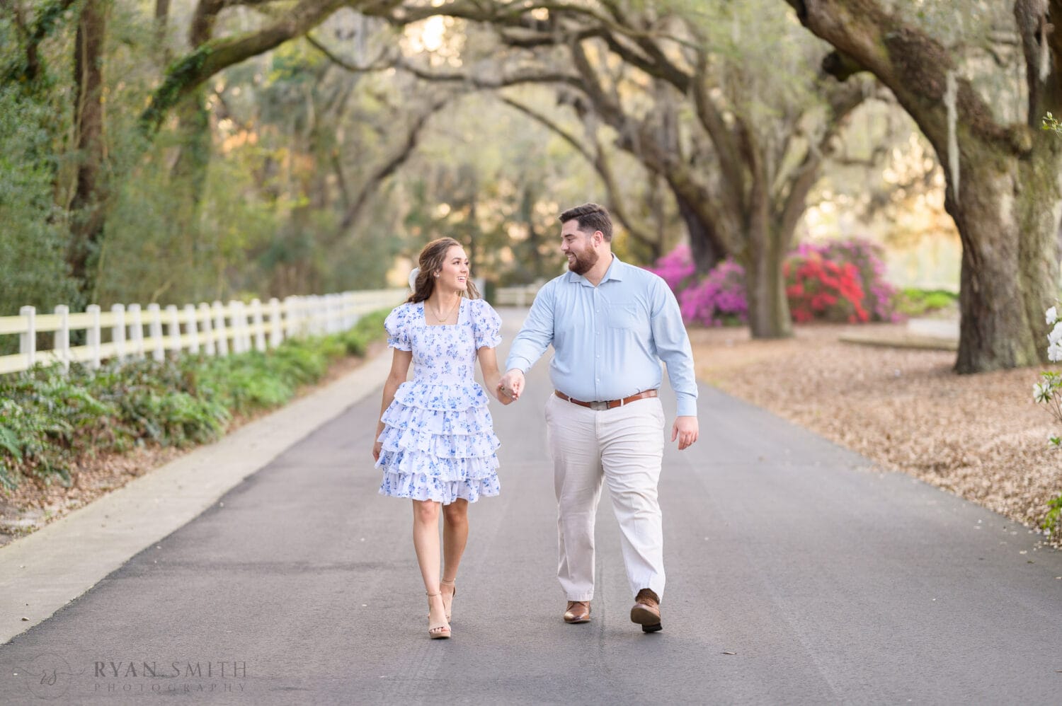 Holding hands walking under the oaks - Caledonia Golf and Fish Club