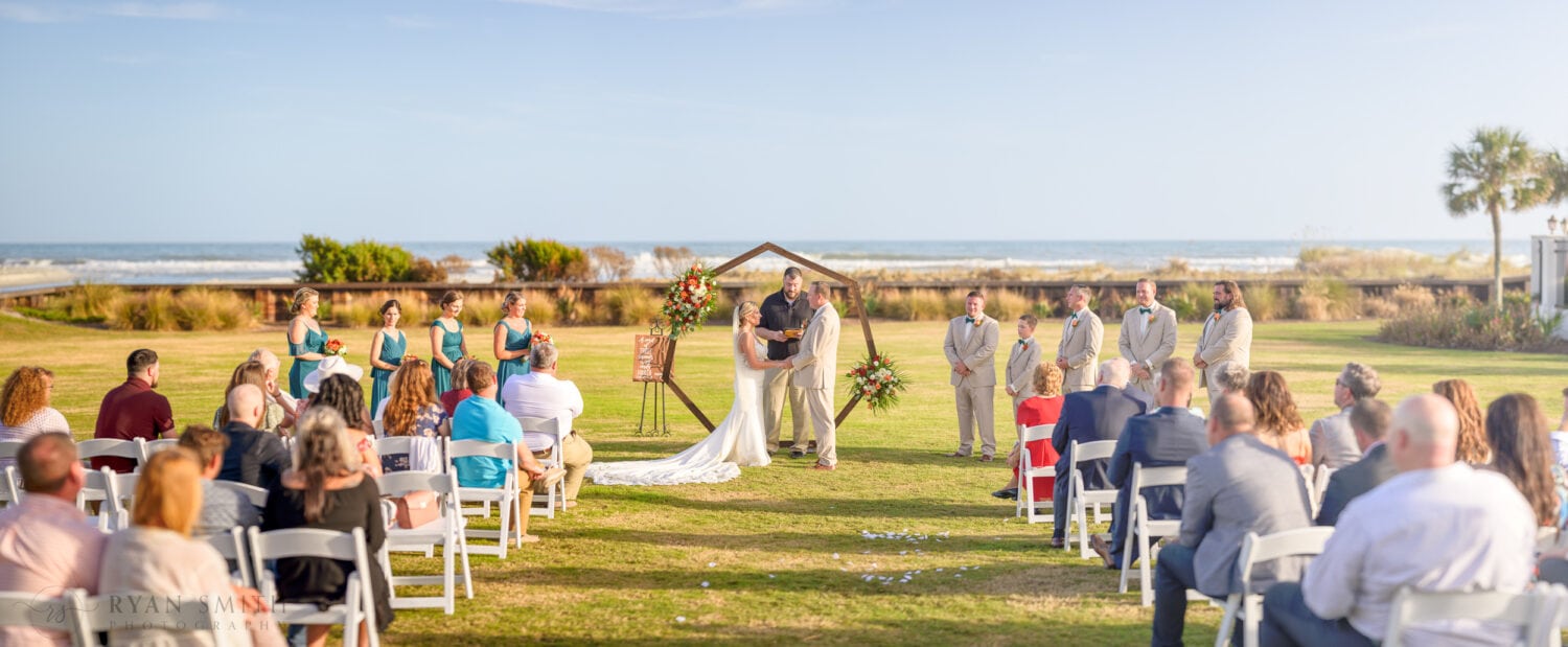 Wide angle of ceremony on the lawn by the clubhouse - Dunes Golf & Beach Club