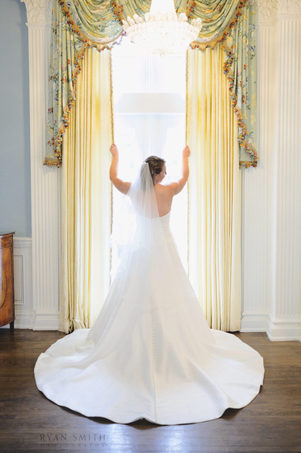 Bride standing in the window light - Pine Lakes Country Club
