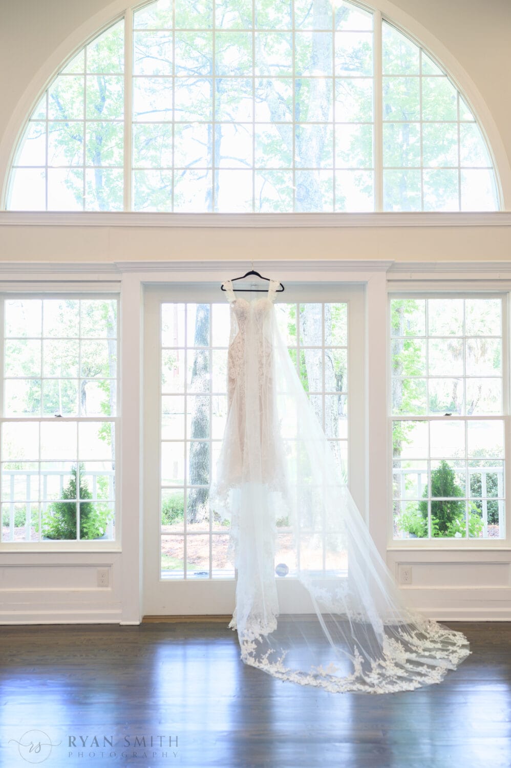 Bride's dress and veil hanging in the window - The Village House at Litchfield