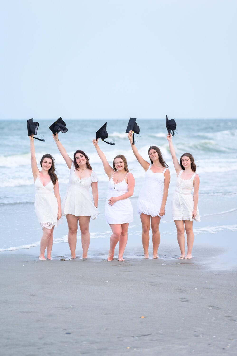 Five senior girls holding their caps in the air - Myrtle Beach State Park