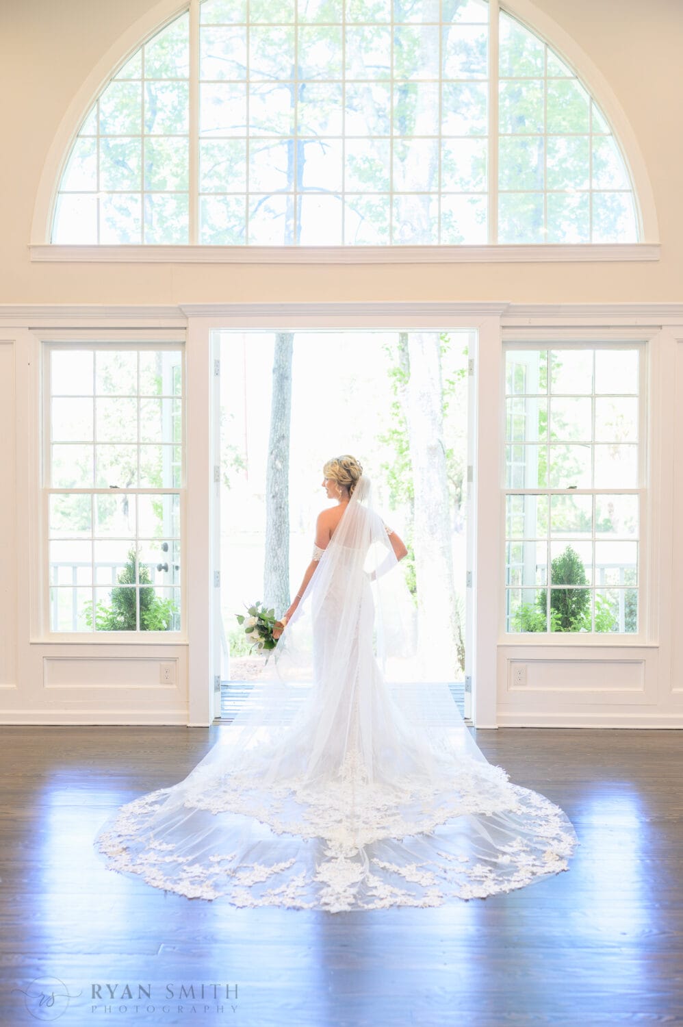 Portraits of the bride in the window light with her dress flowing out behind her - The Village House at Litchfield