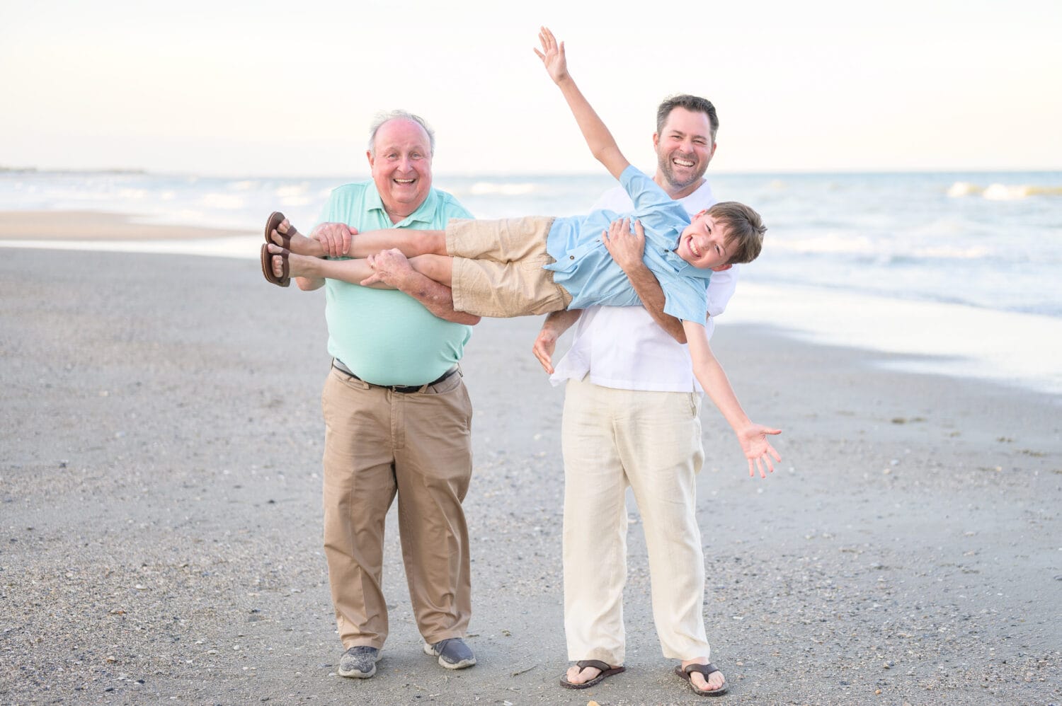 Happy father and grandfather lifting boy in the air - Pawleys Island