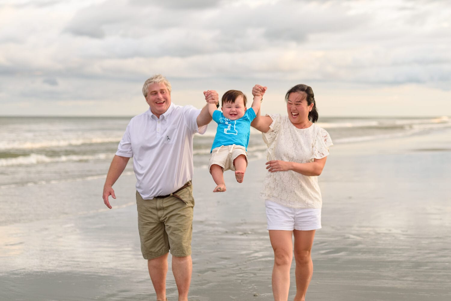 Baby having lots of fun with mom and dad on the beach - Surfside Beach