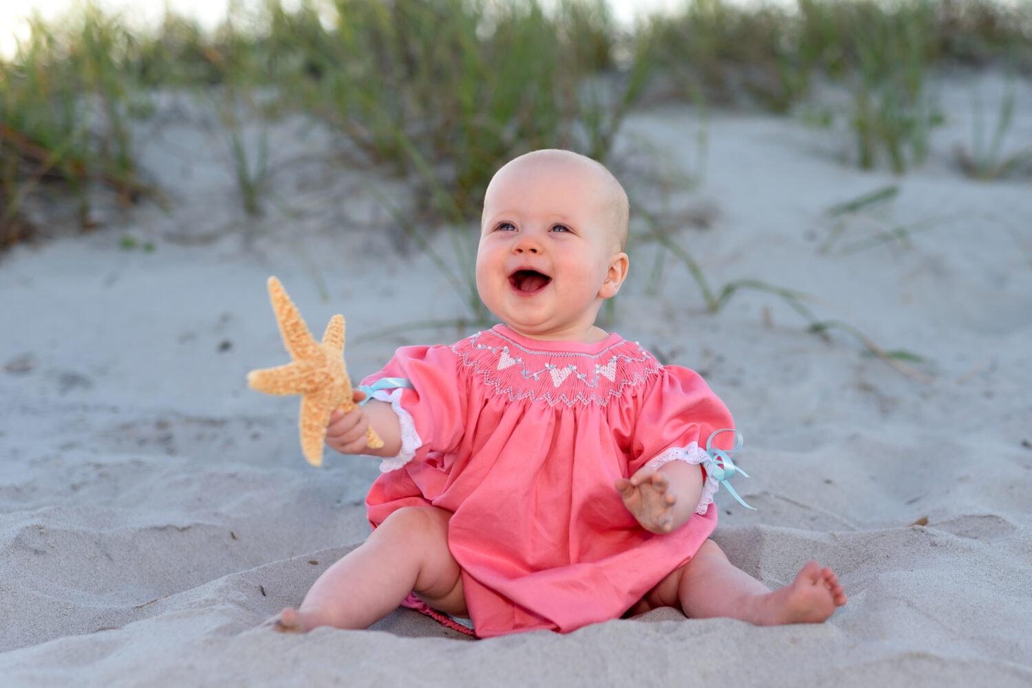 Baby holding a starfish with huge smile - Myrtle Beach State Park