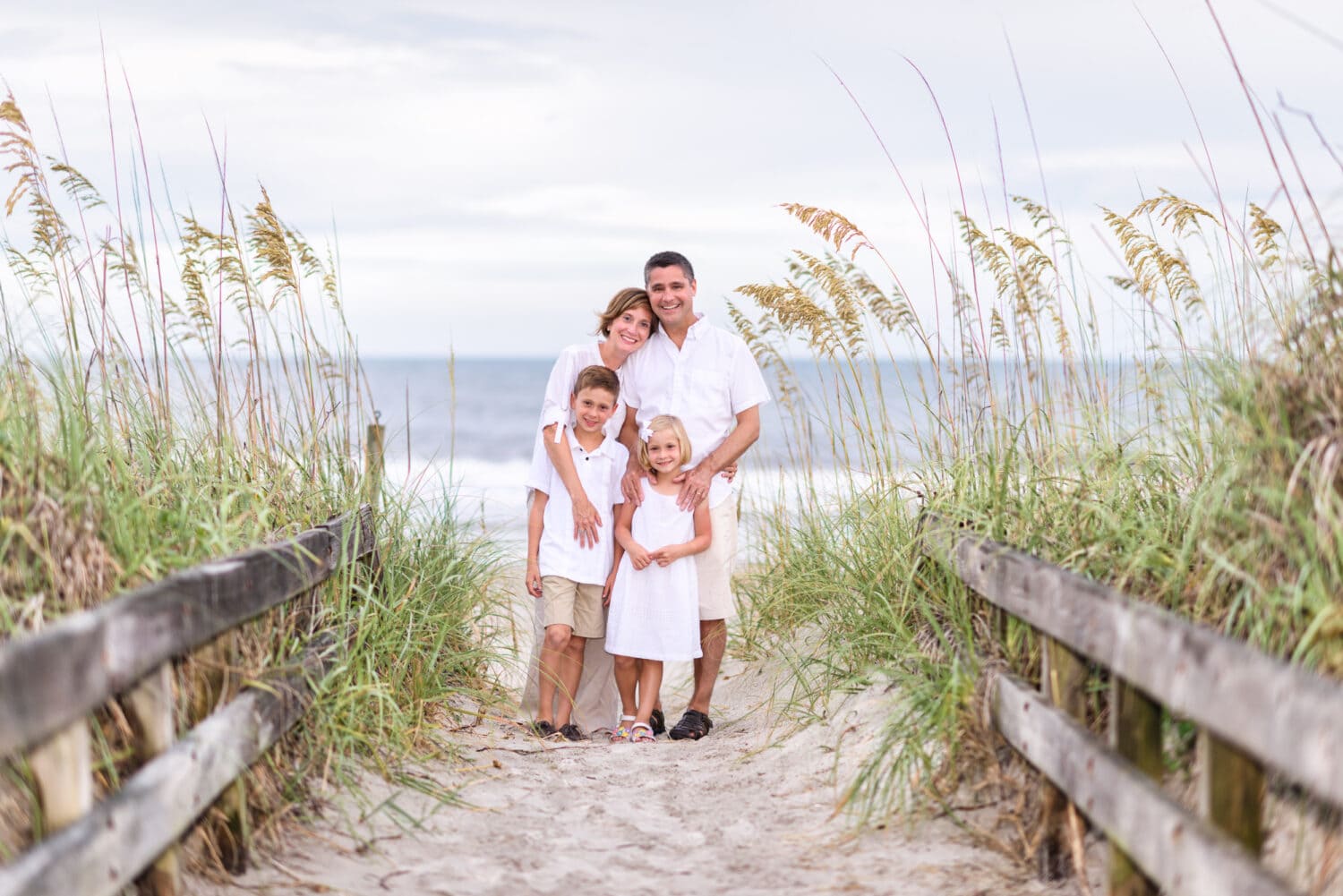 Family of 4 standing between the sea oats - Myrtle Beach State Park