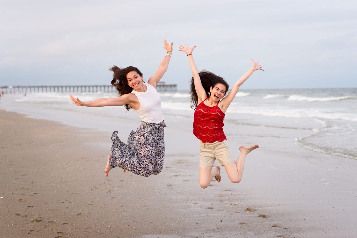 Identical twins jumping in front of the ocean - Myrtle Beach State Park