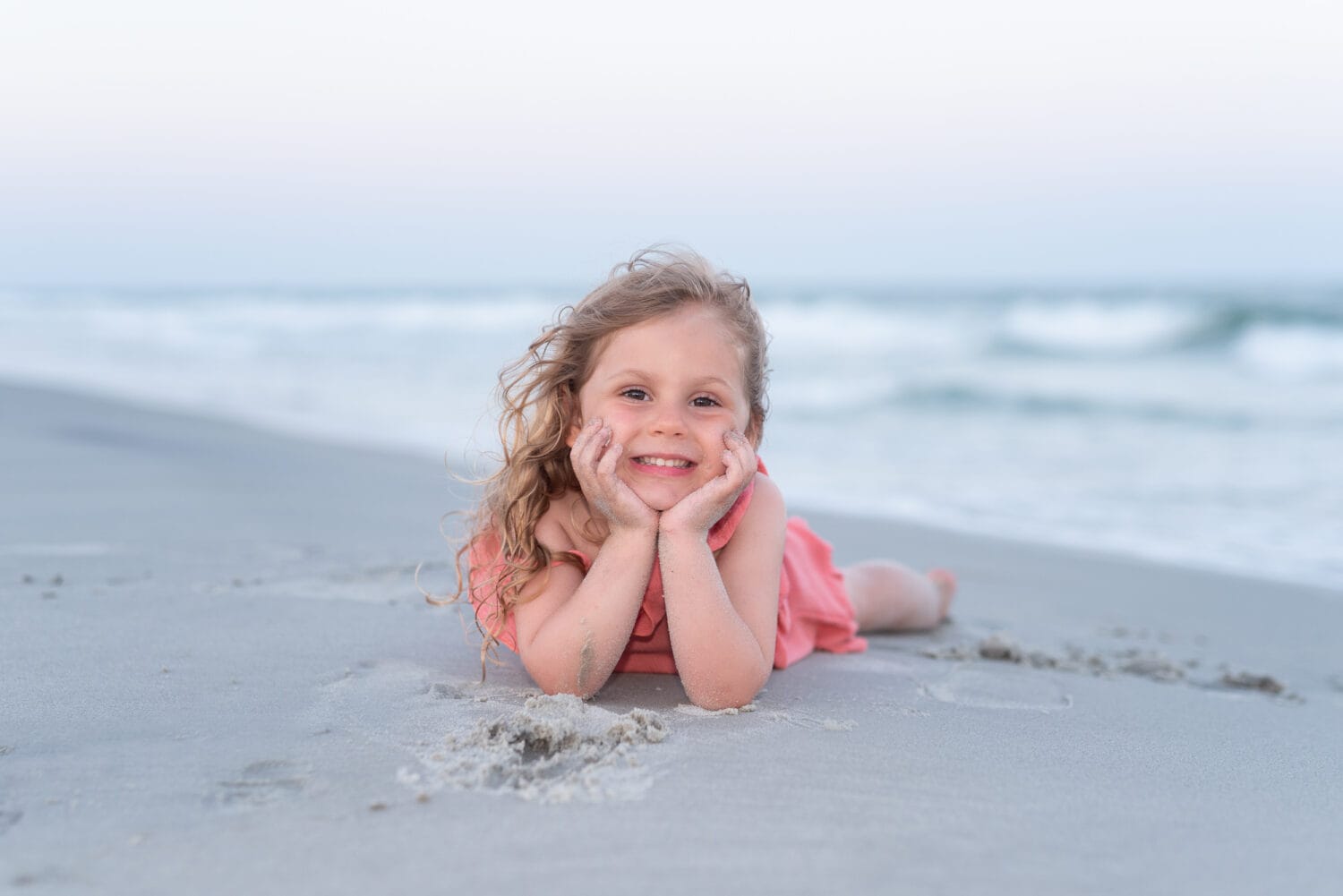 Little girl laying by the ocean - Huntington Beach State Park