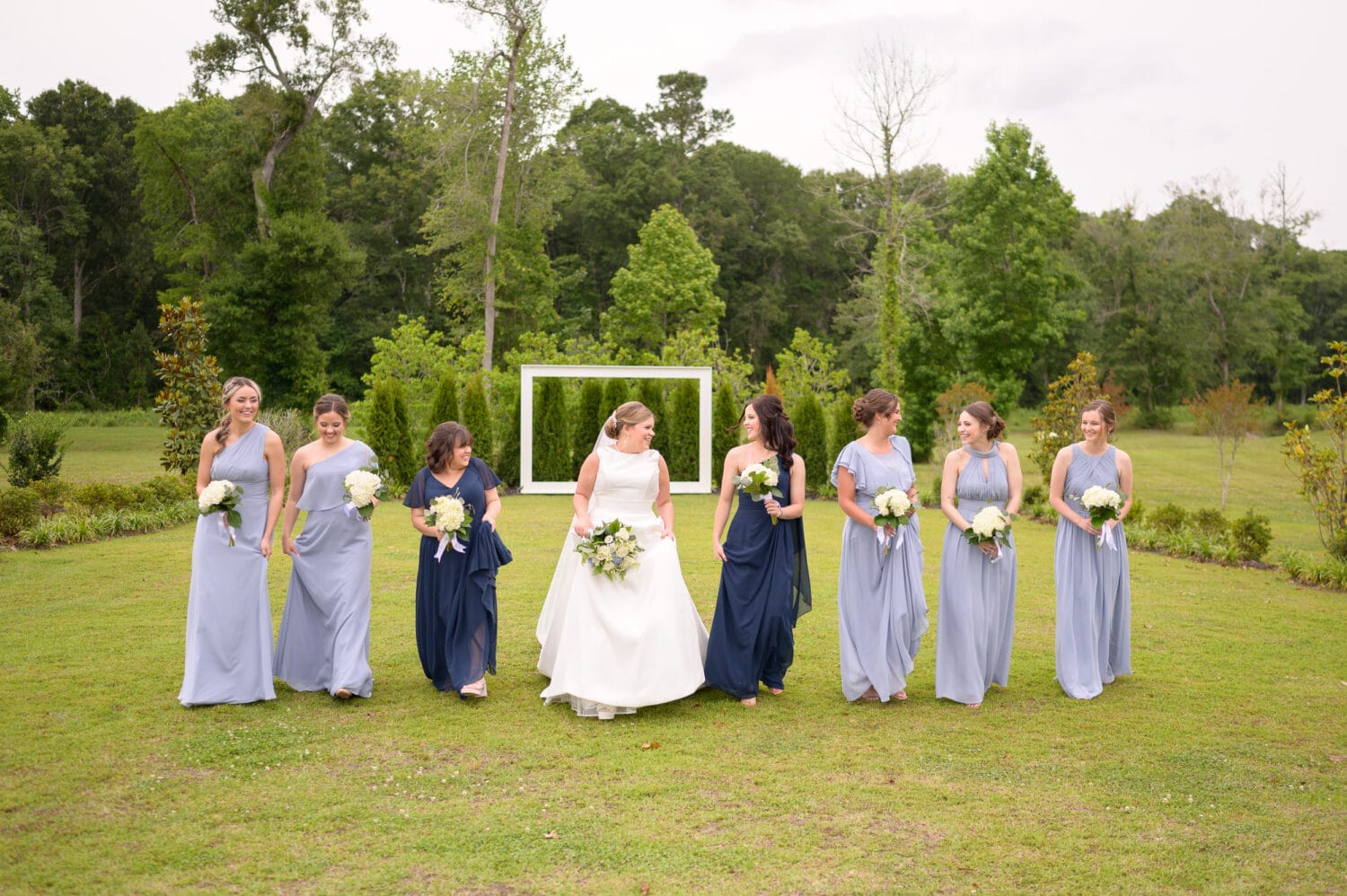 Bride and bridesmaids in front of the frame on the lawn - The Venue at White Oaks Farm