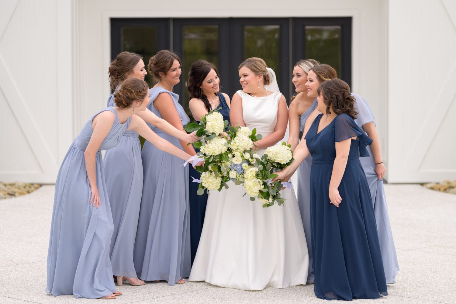 Bridesmaids holding flowers together - The Venue at White Oaks Farm