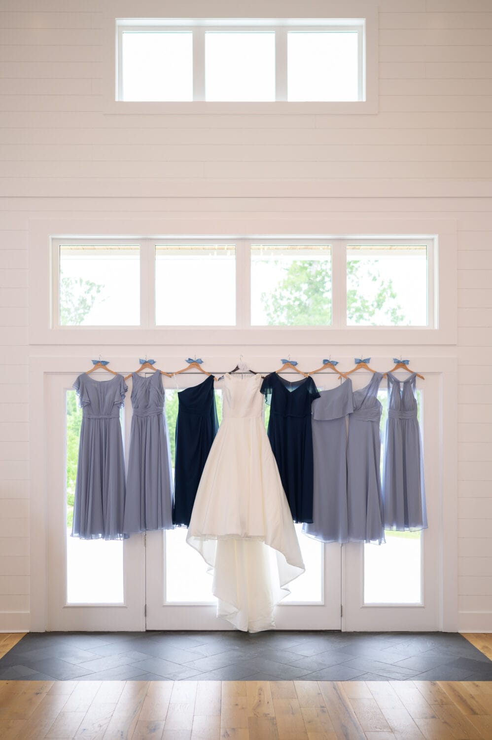 Dresses hanging in the windowlight  - The Venue at White Oaks Farm