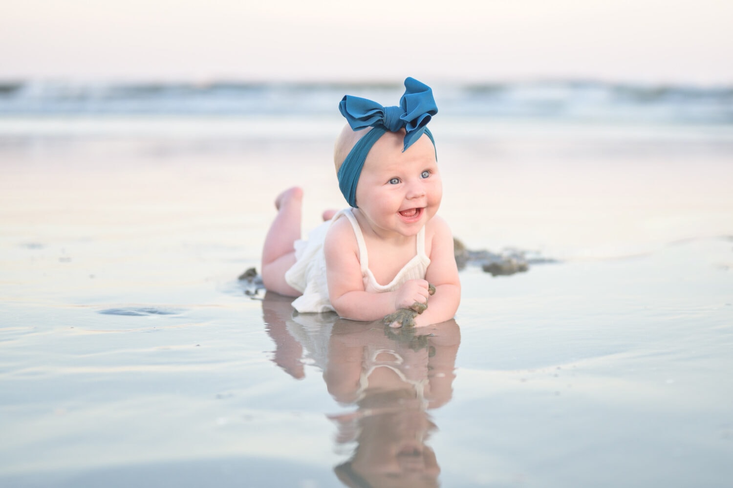 Happy baby girl laying in the edge of the water - North Myrtle Beach