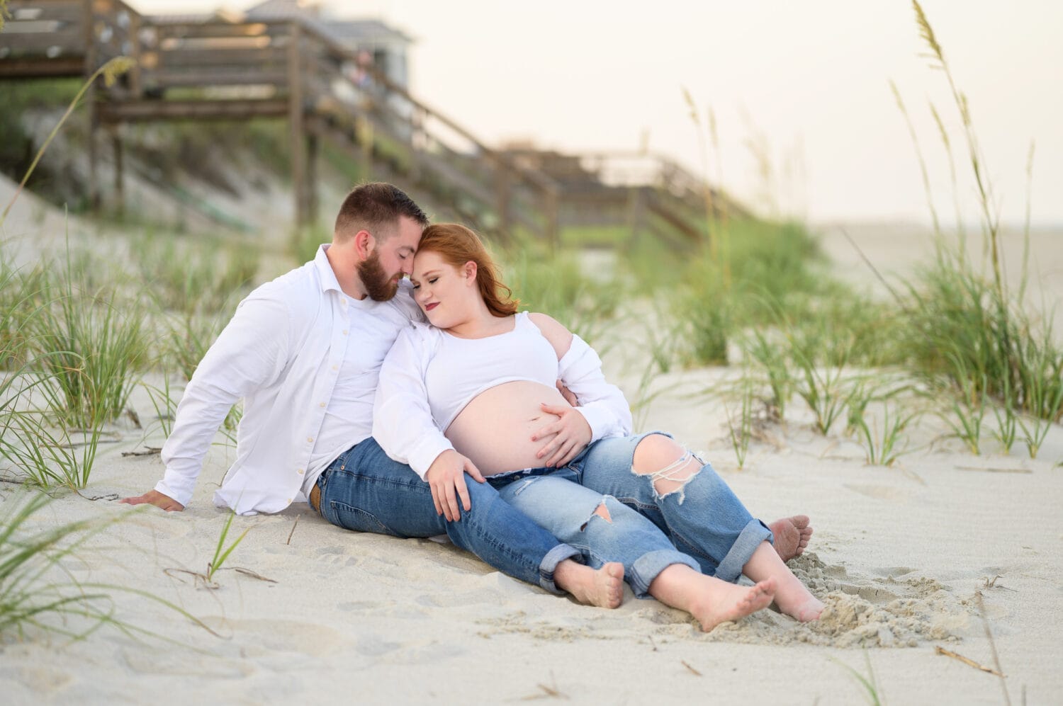Maternity Portrait laying on the beach together - The Pelican Inn
