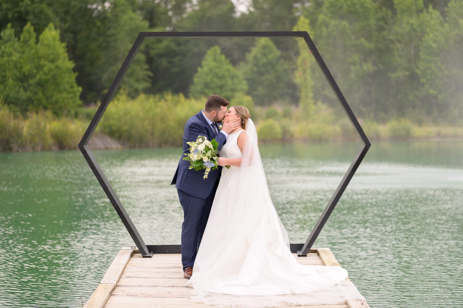 Portraits of the bride and groom in front of the hexagon on the lake - The Venue at White Oaks Farm
