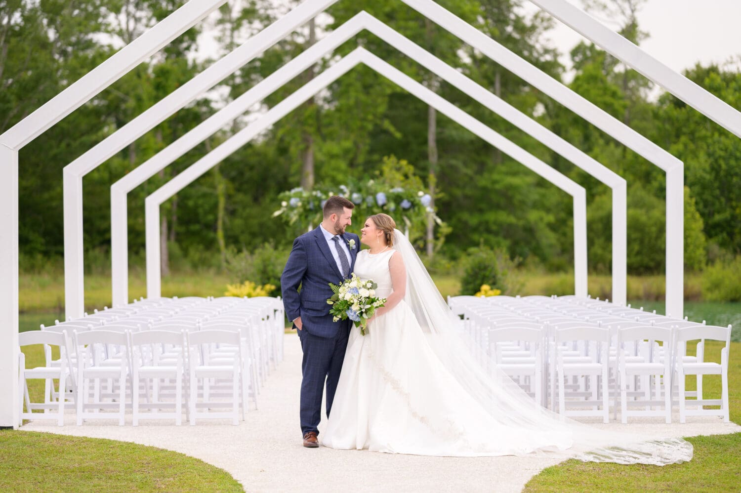 Portraits of the bride and groom under the ceremony arches - The Venue at White Oaks Farm