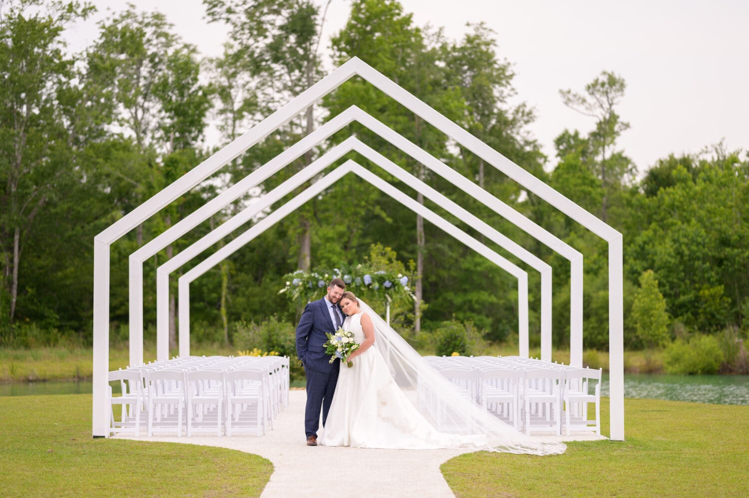 Portraits of the bride and groom under the ceremony arches - The Venue at White Oaks Farm