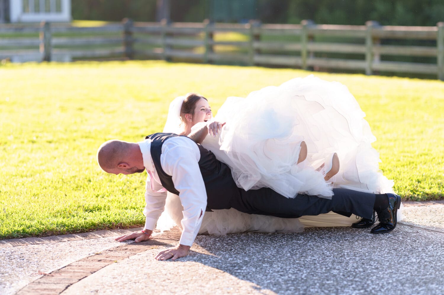 Groom doing pushups with bride on his back and falling - The Pavilion at Pepper Plantation