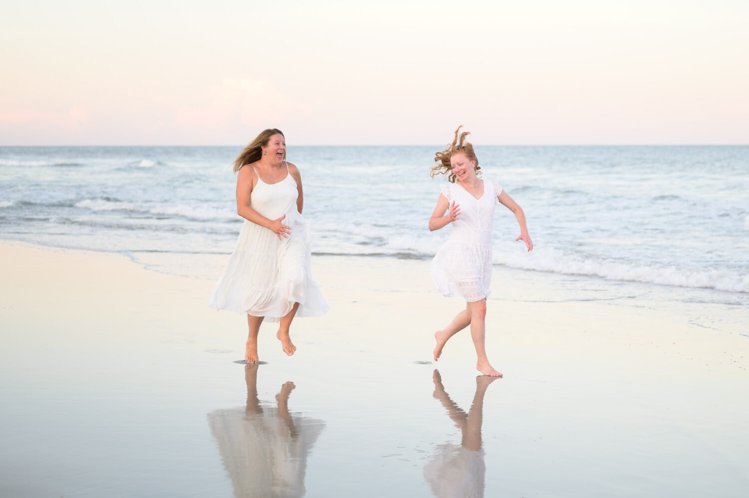 Sisters having fun running down the beach - Huntington Beach State Park