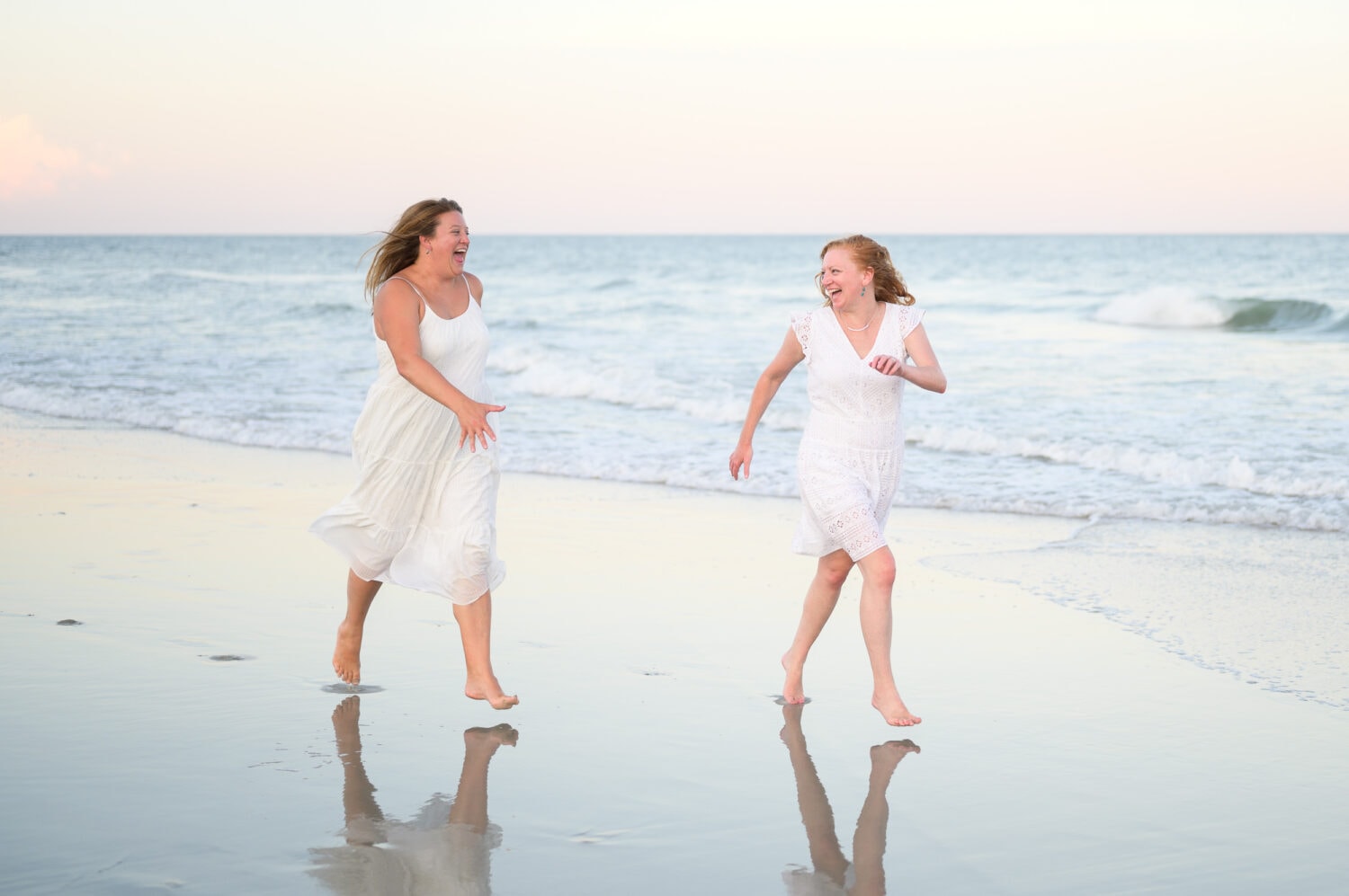 Sisters having fun running down the beach - Huntington Beach State Park