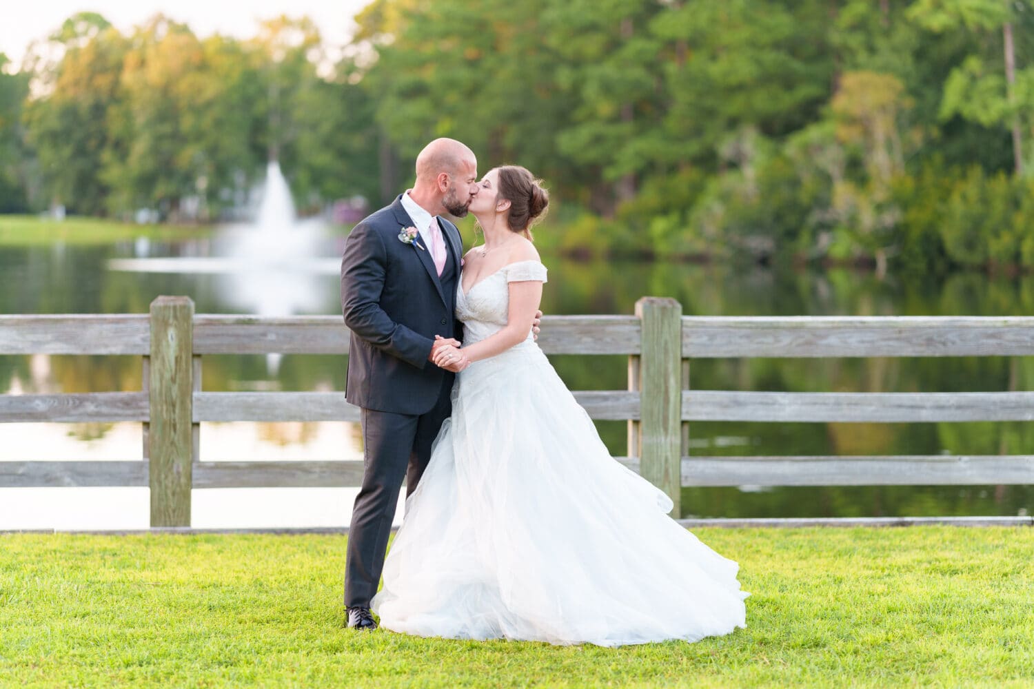 Sunset portraits with bride and groom in front of the lake and fountain - The Pavilion at Pepper Plantation