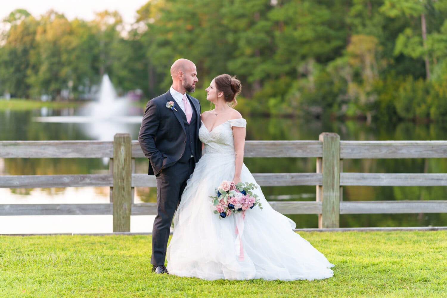 Sunset portraits with bride and groom in front of the lake and fountain - The Pavilion at Pepper Plantation