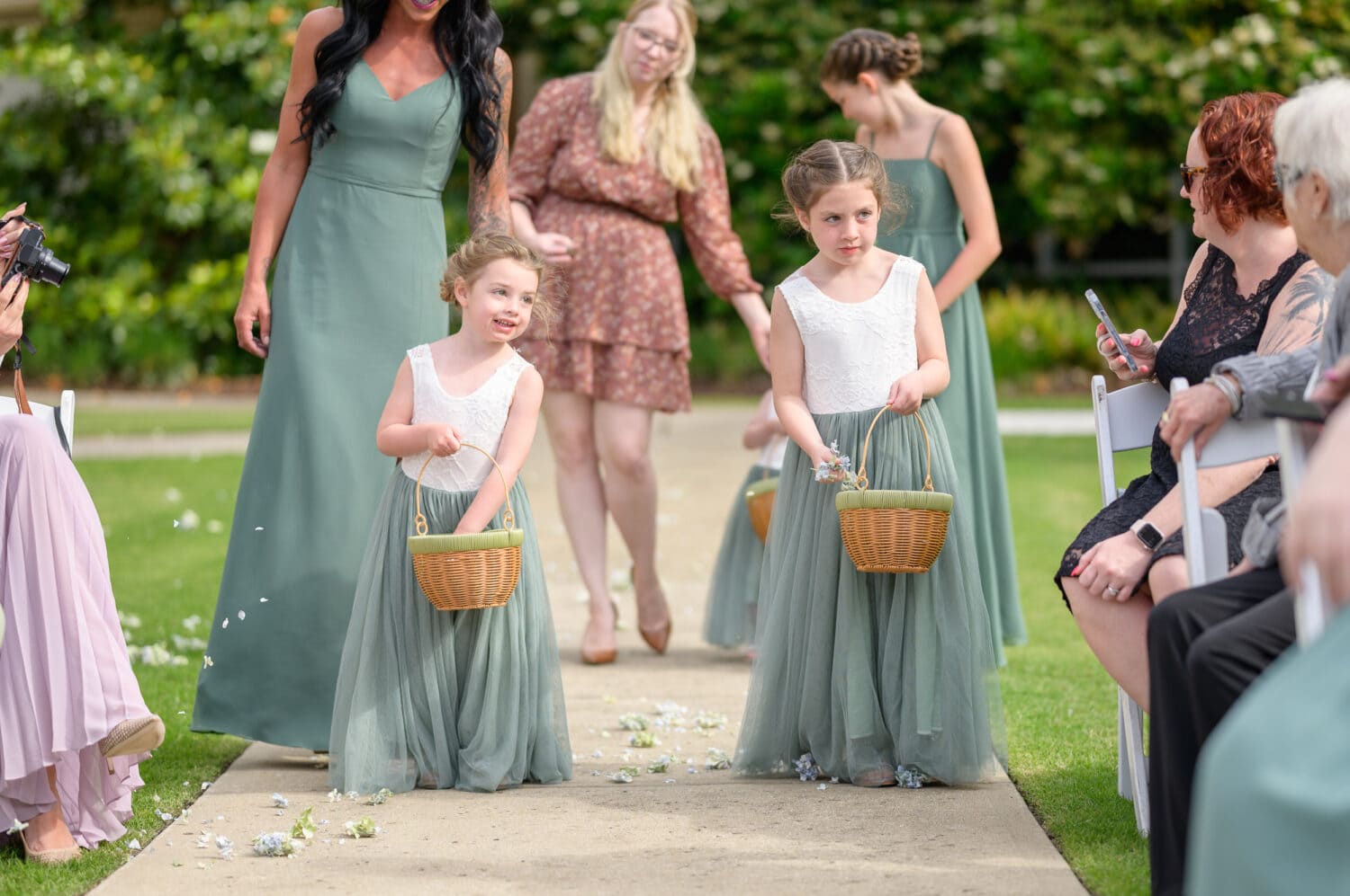 Bride and groom's daughters as flower girls and bridesmaids walking down the aisle - The Marina Inn