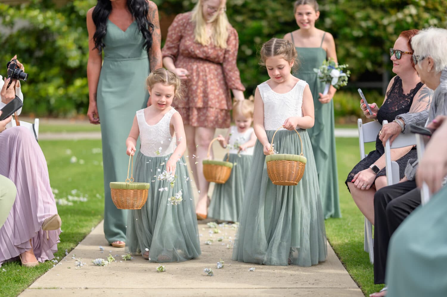 Bride and groom's daughters as flower girls and bridesmaids walking down the aisle - The Marina Inn