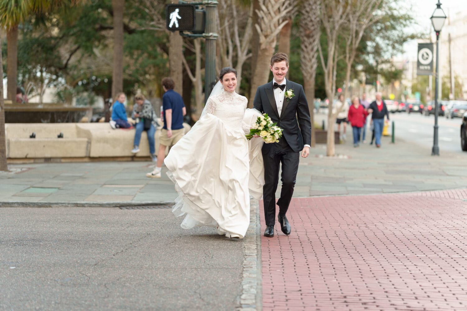 Bride and groom on the crosswalk running back to hotel - Marion Square Charleston